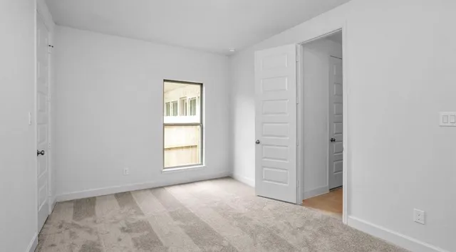 an empty room with windows and closet