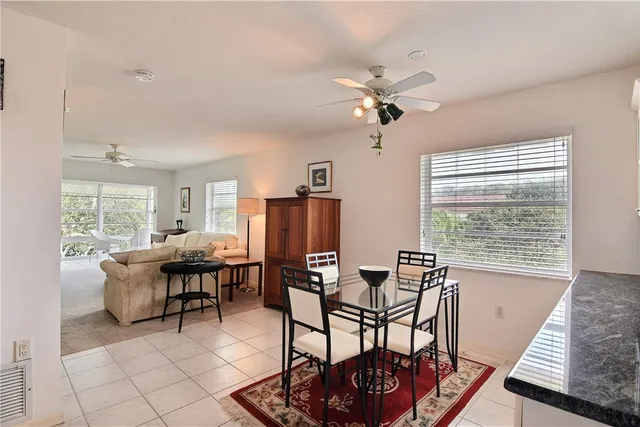a dining room with furniture a chandelier and wooden floor