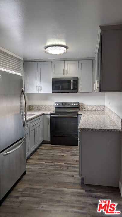 7300 Lennox Avenue, Unit J15 Van Nuys, CA 91405 - Photo 5 of 25 a kitchen with stainless steel appliances granite countertop a sink a stove and a refrigerator