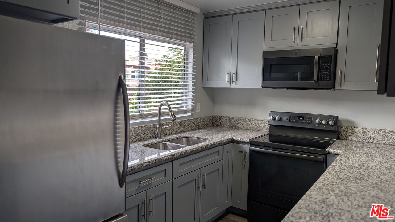 7300 Lennox Avenue, Unit J15 Van Nuys, CA 91405 - Photo 6 of 25 a kitchen with a sink and a stove top oven