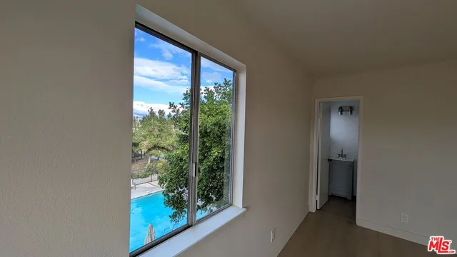 a view of hallway with a large window and wooden floor