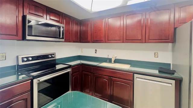 a kitchen with stainless steel appliances granite countertop a refrigerator and a sink