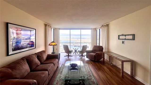 a living room with furniture a wooden floor and a chandelier