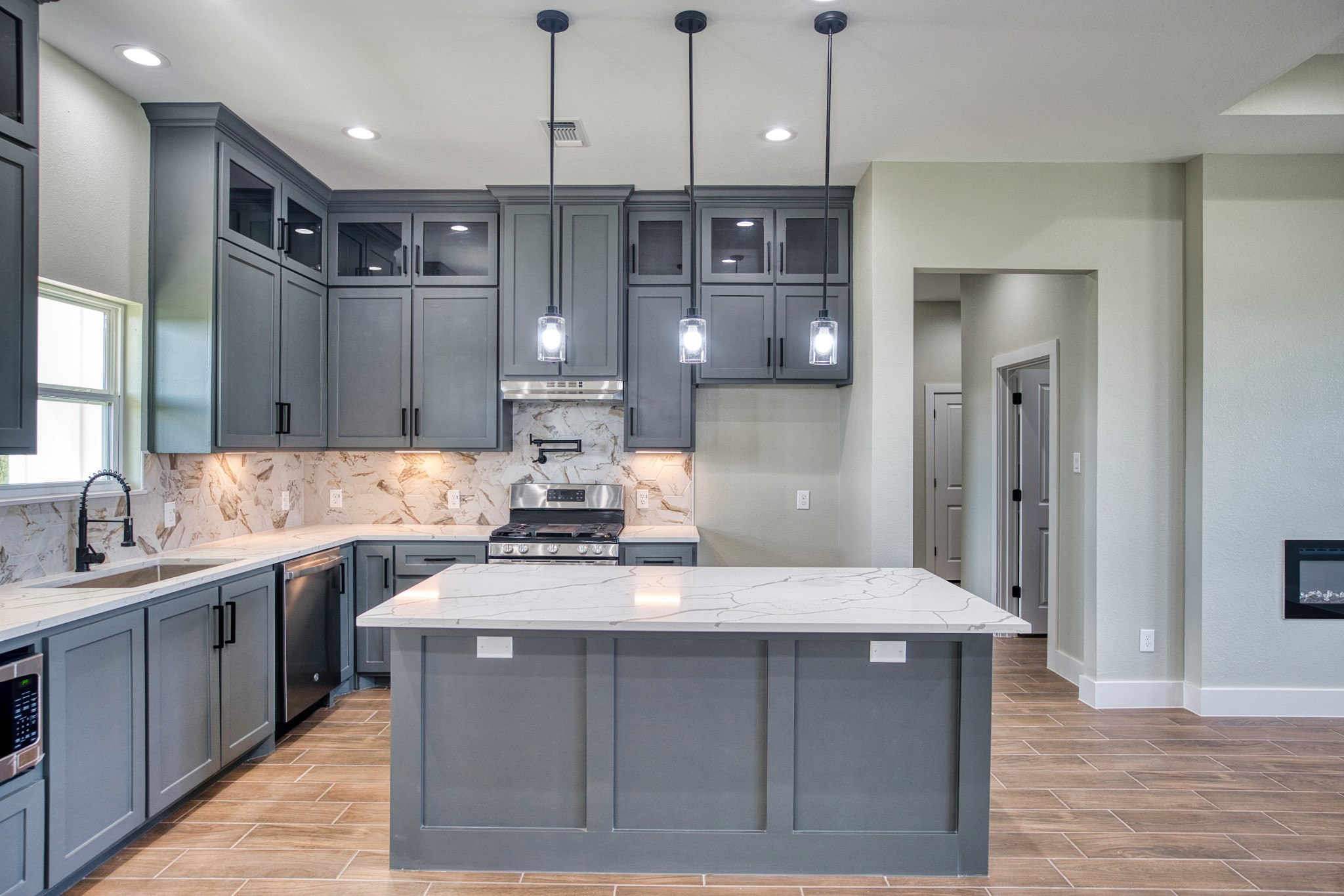 925 Buffalo Trail Angleton, TX 77515 - Photo 18 of 45 a large kitchen with a large center island wooden floor stainless steel appliances and cabinets