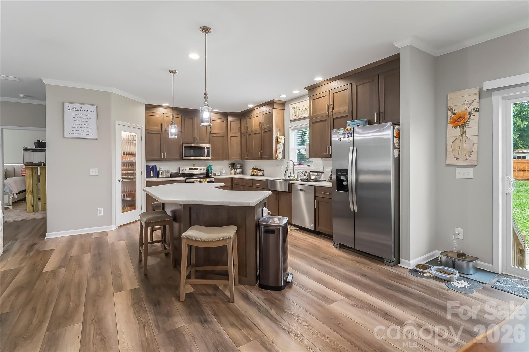 3511 Randleman Road Iron Station, NC 28080 - Photo 11 of 31 a kitchen with stainless steel appliances a dining table chairs stove refrigerator and cabinets