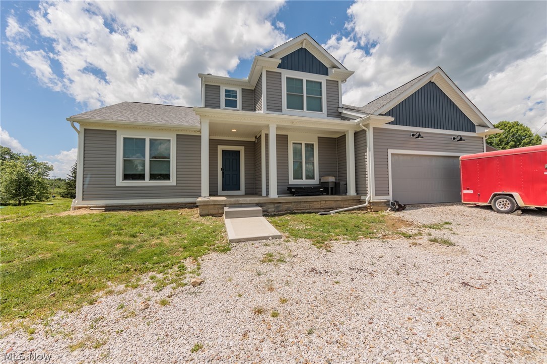 View of front of property featuring a garage and a porch