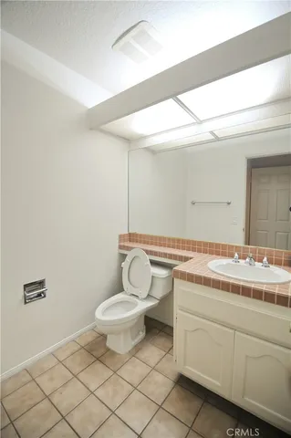 a bathroom with a granite countertop sink mirror vanity and toilet