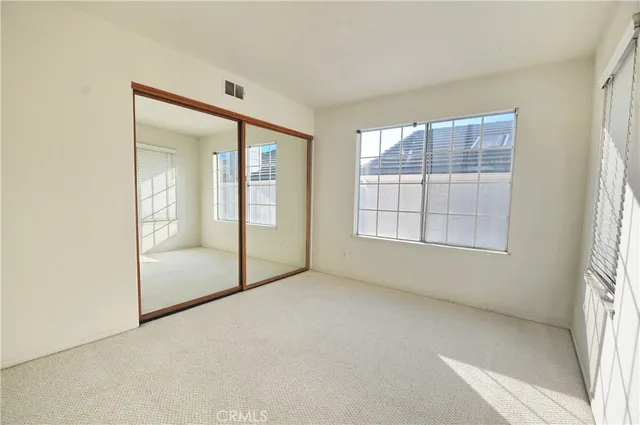 an empty room with windows and mirror