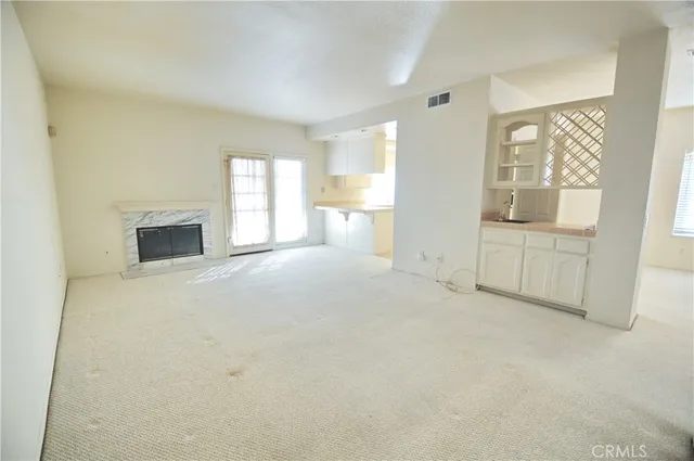 an empty room with windows and fireplace