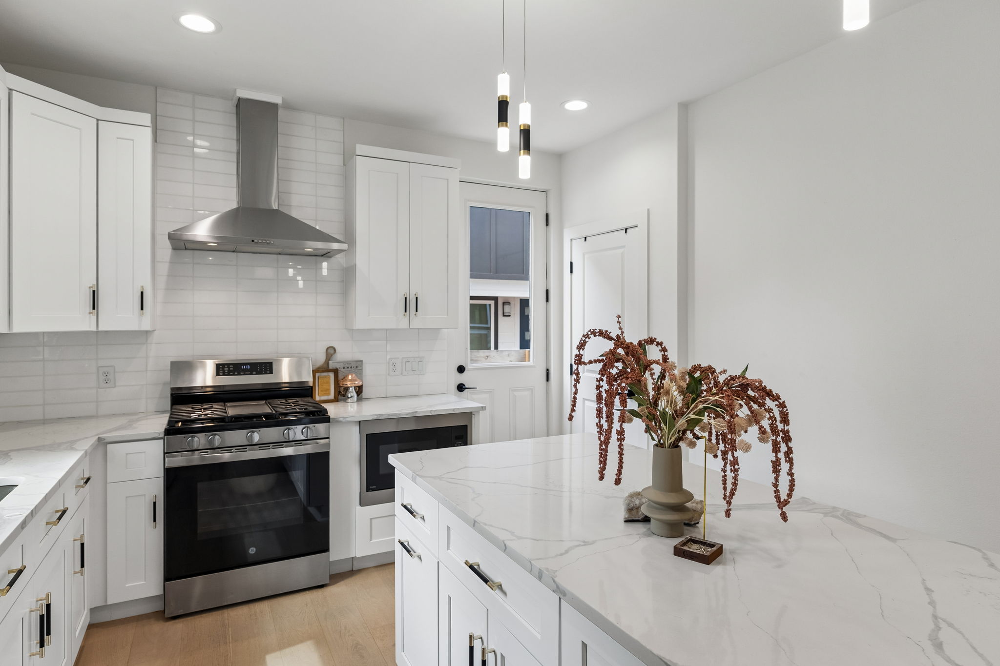 5305 Ledesma Road, Unit 1 Austin, TX 78721 - Photo 7 of 26 A detailed shot of the quartz island and prep area. The marbling in the stone adds a touch of luxury, while the view highlights the seamless integration of the stainless steel vent hood and white cabinetry.