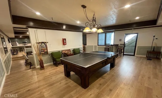 a living room with stainless steel appliances kitchen island granite countertop a table chairs and a refrigerator