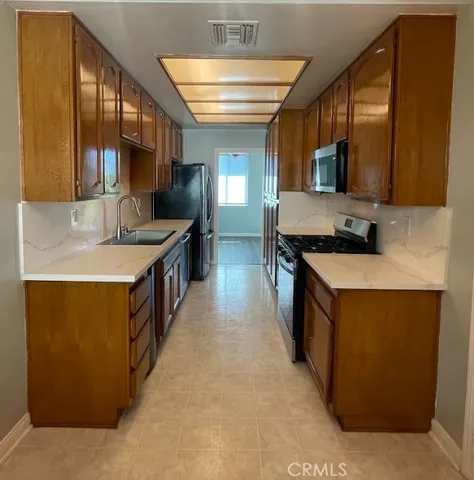 a kitchen with stainless steel appliances a sink and a stove
