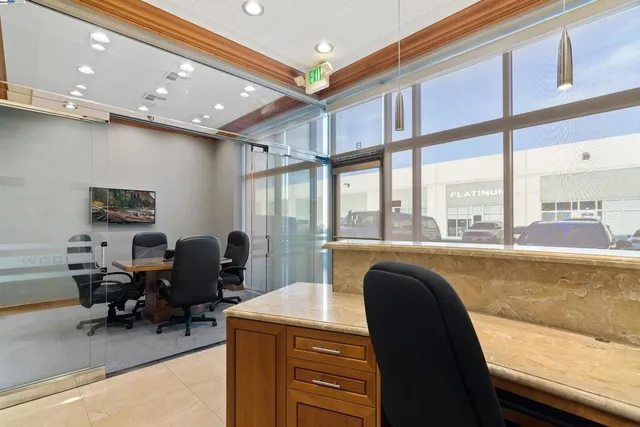 a view of a workspace with furniture and a window