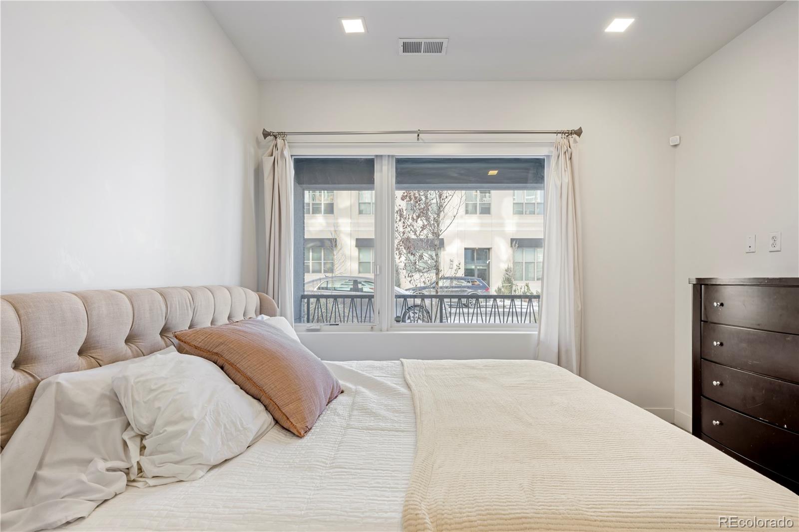 1898 South Bannock Street, Unit 103 Denver, CO 80223 - Photo 11 of 22 a living room with a bed and a large window