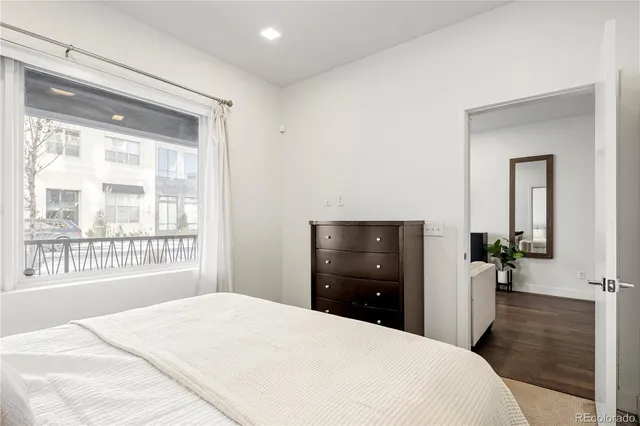 a bedroom with a bed and a large window