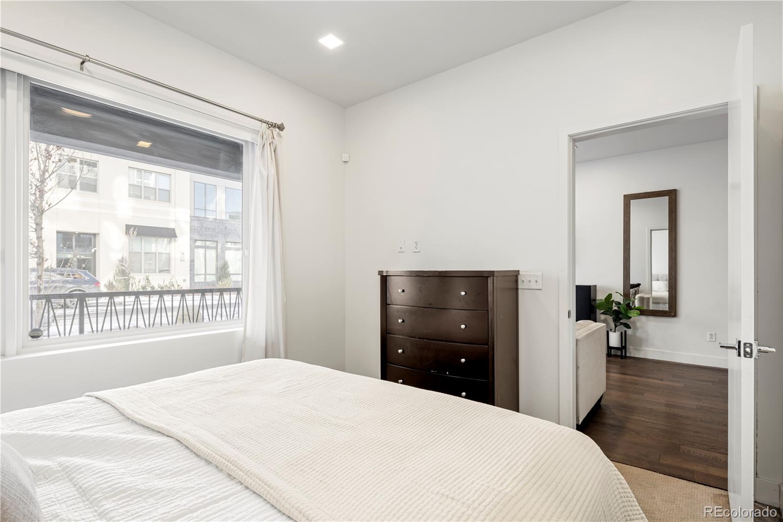 1898 South Bannock Street, Unit 103 Denver, CO 80223 - Photo 12 of 22 a bedroom with a bed and a large window
