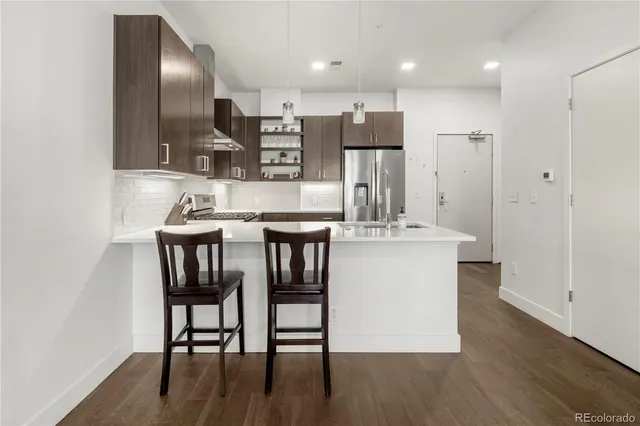 a kitchen with a table chairs refrigerator and microwave
