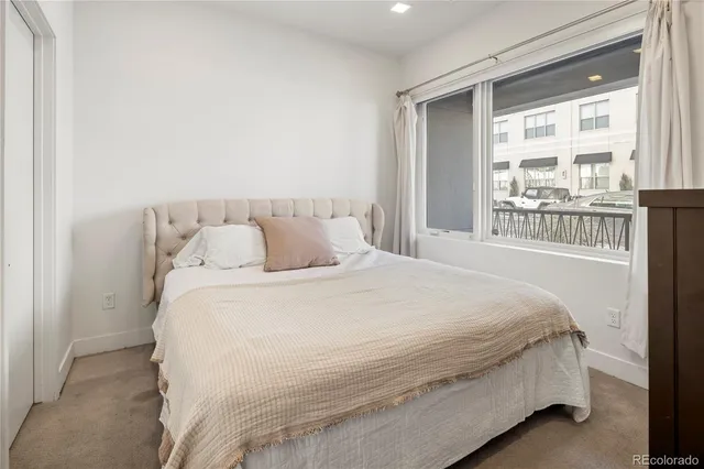 a large bed sitting in a bedroom next to a window