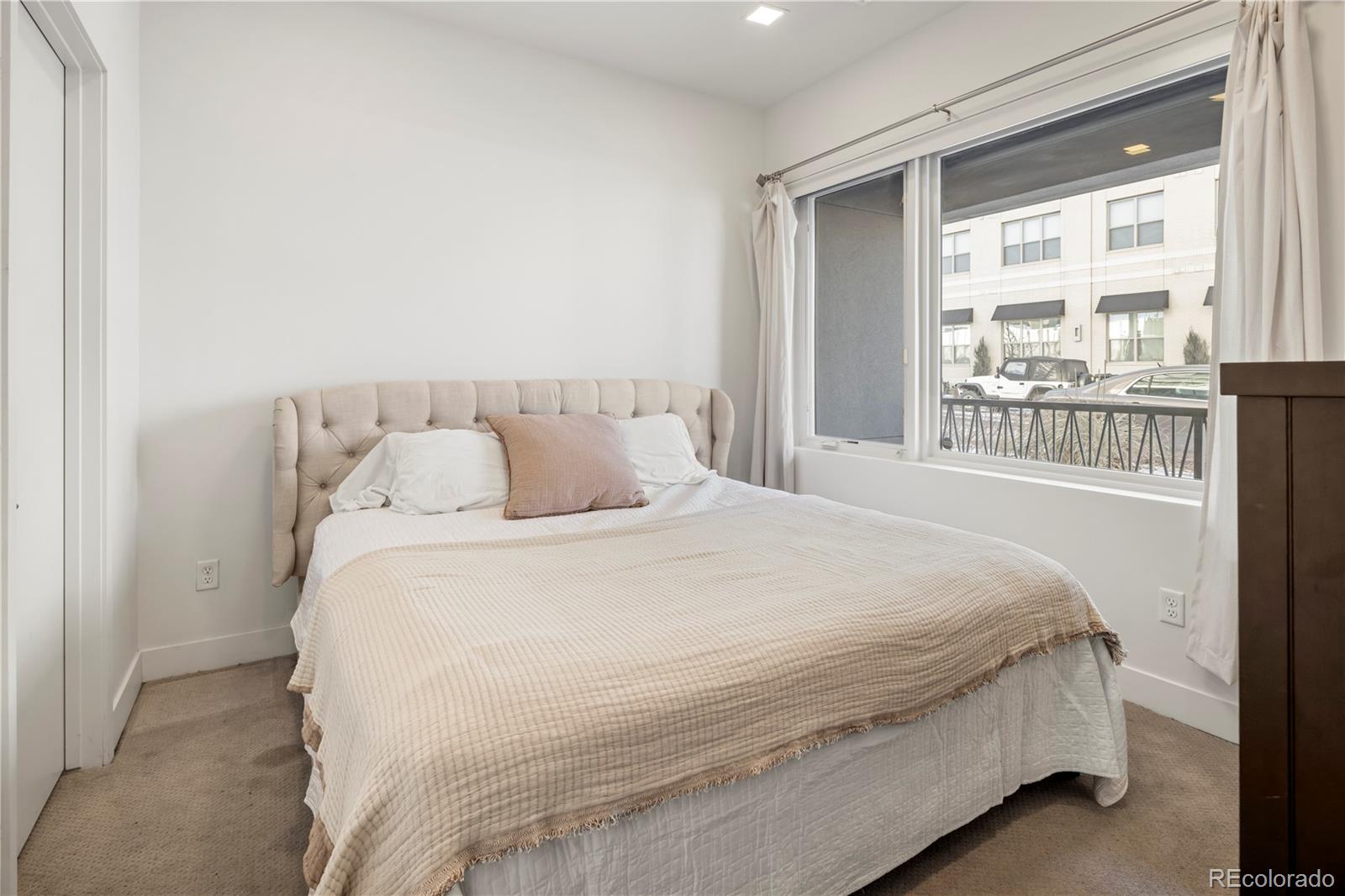 1898 South Bannock Street, Unit 103 Denver, CO 80223 - Photo 8 of 22 a large bed sitting in a bedroom next to a window