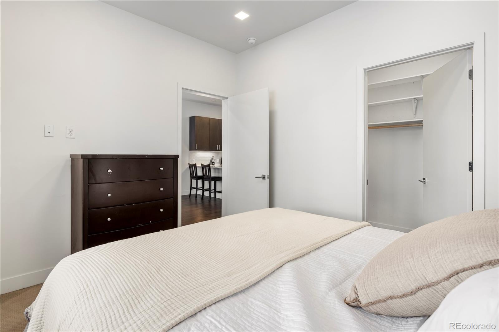 1898 South Bannock Street, Unit 103 Denver, CO 80223 - Photo 9 of 22 a bedroom with a bed and a dresser