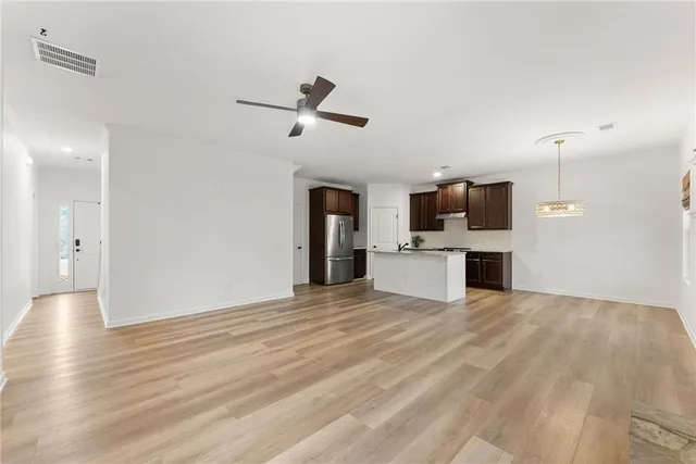 a view of kitchen with stainless steel appliances kitchen island sink refrigerator and microwave