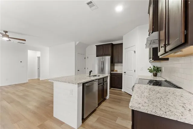 a kitchen with stainless steel appliances granite countertop a sink stove and refrigerator