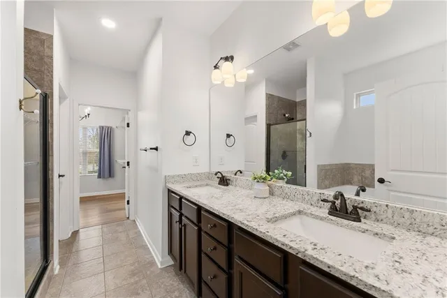 a bathroom with a granite countertop sink double and shower