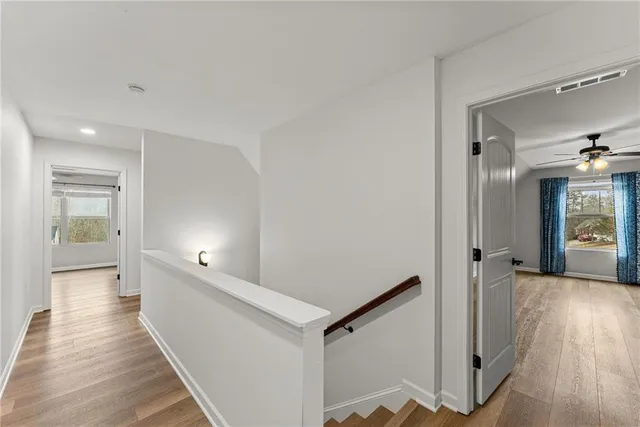 a view of a hallway with wooden floor and staircase
