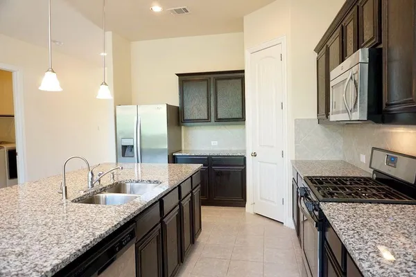 a kitchen with stainless steel appliances granite countertop a sink and a microwave