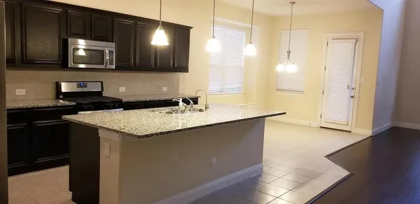 a view of a room with wooden floor chandelier and windows