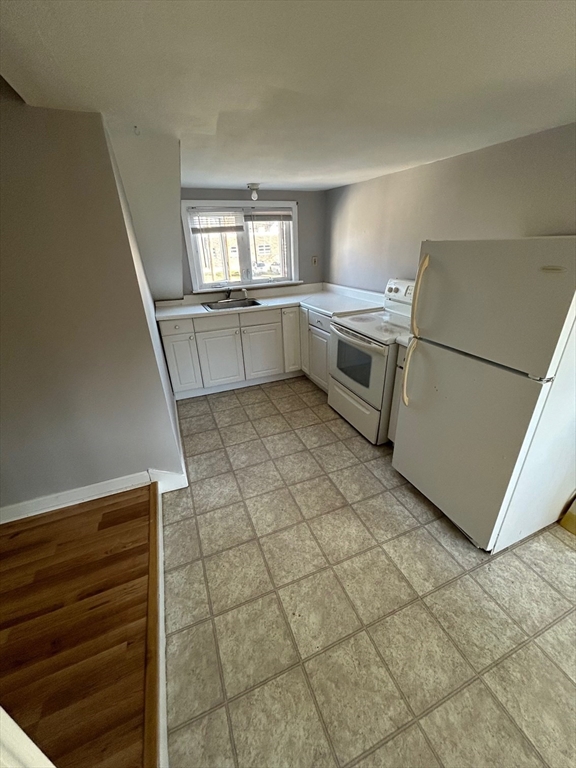 441 King Street, Unit G Littleton, MA 01460 - Photo 2 of 7 a kitchen with a sink a stove cabinets and utility room