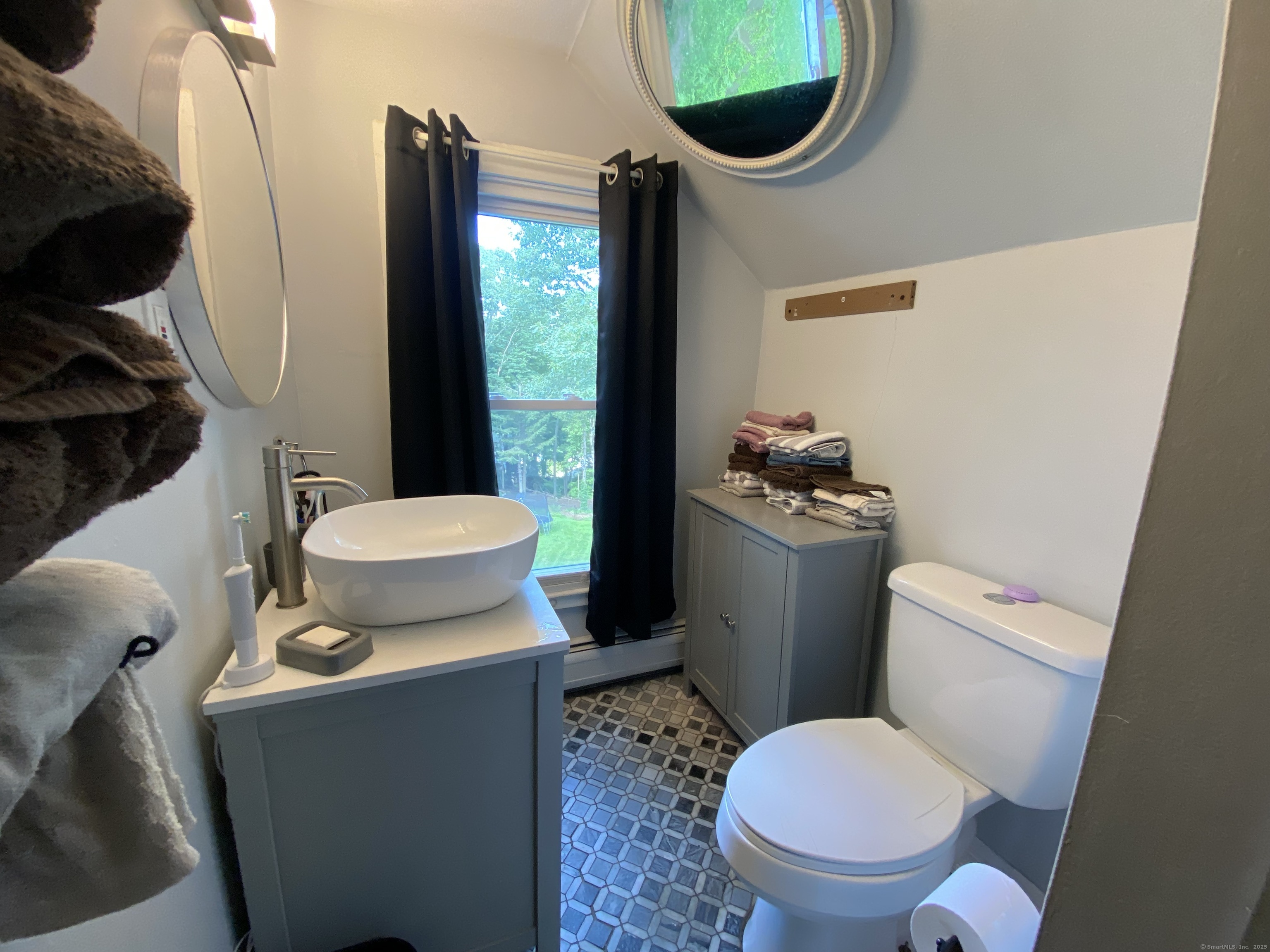 148 Hillside Avenue Torrington, CT 06790 - Photo 24 of 38 a white toilet sitting next to a bathroom sink and a mirror