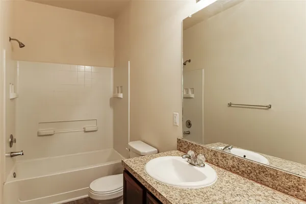 a bathroom with a granite countertop sink toilet and shower