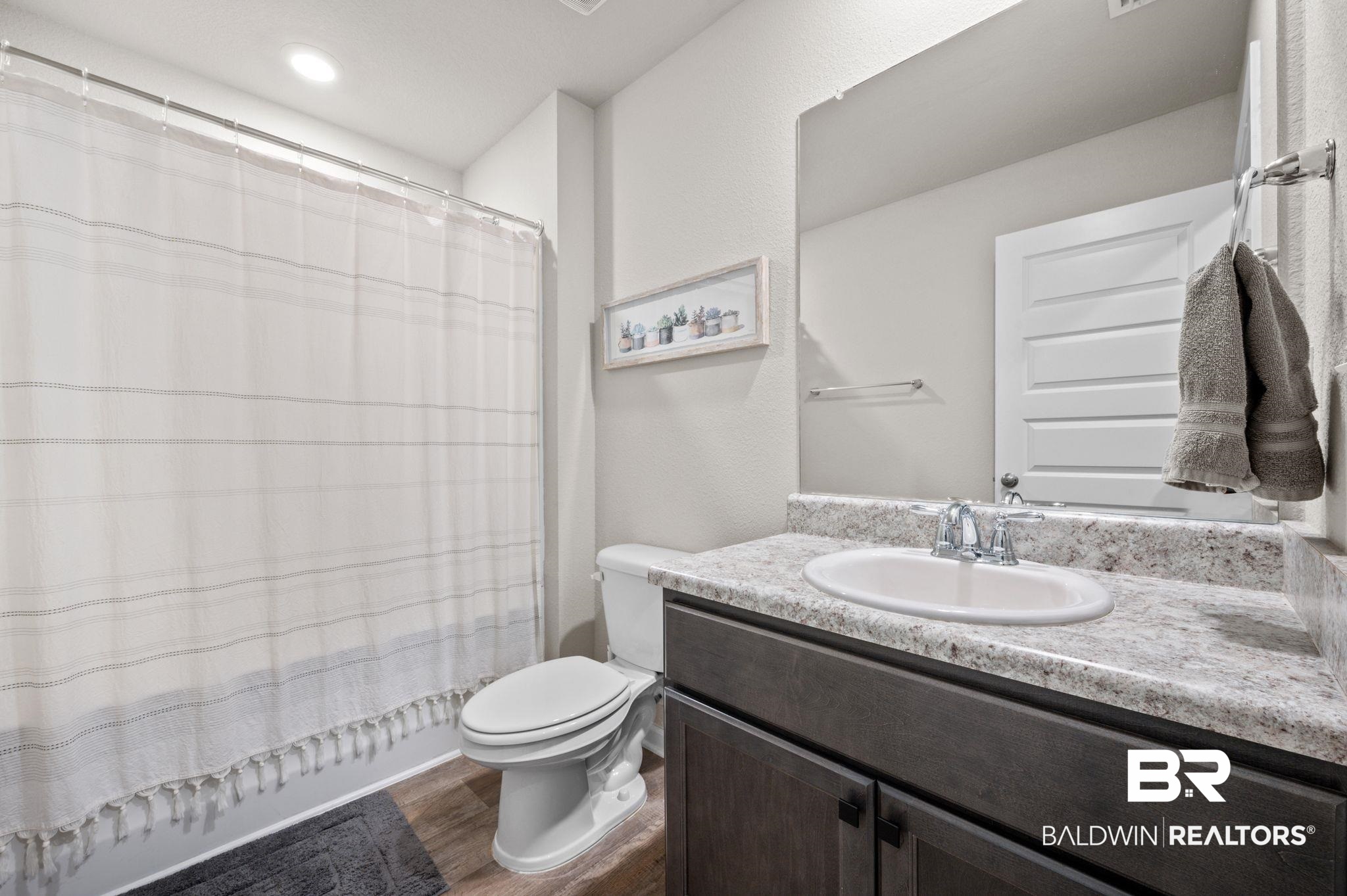 10306 Brodick Loop Spanish Fort, AL 36527 - Photo 25 of 35 Full bathroom with hardwood / wood-style floors, vanity, shower / tub combo, and toilet
