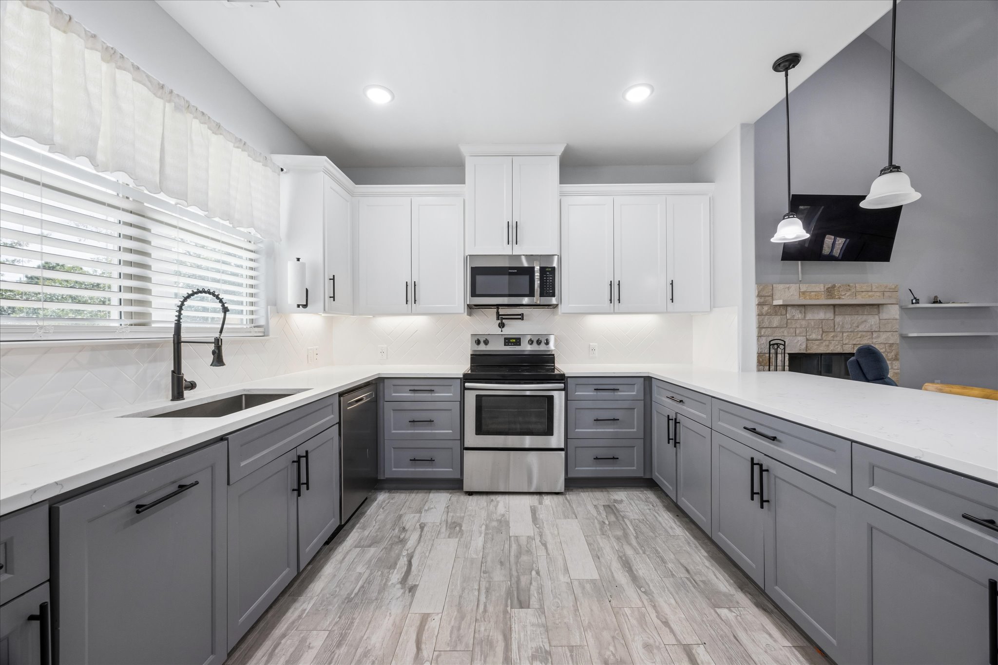 116 Mallard Road Bastrop, TX 78602 - Photo 10 of 31 Crisp white upper cabinets complement slate gray lower cabinetry in this modern kitchen workspace.