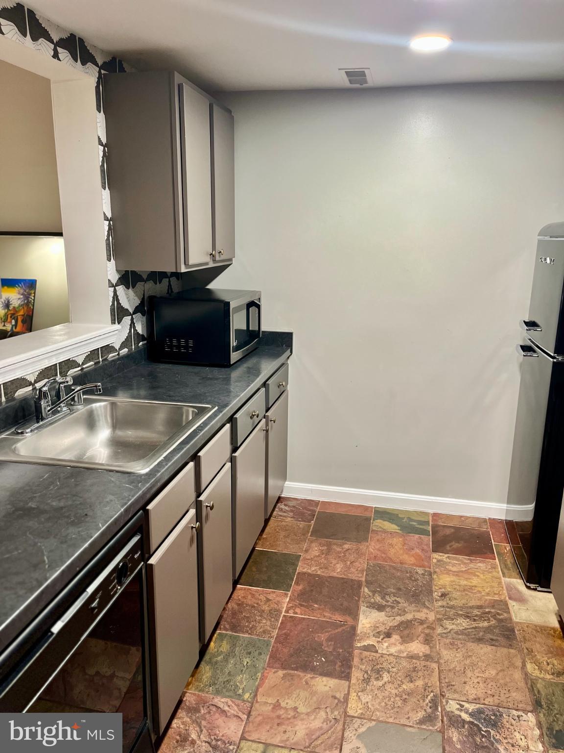 2609 Douglass Road Southeast, Unit 402 Washington, DC 20020 - Photo 11 of 35 a kitchen with stainless steel appliances granite countertop a sink stove and cabinets