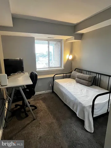 a bedroom with a bed chair and a window