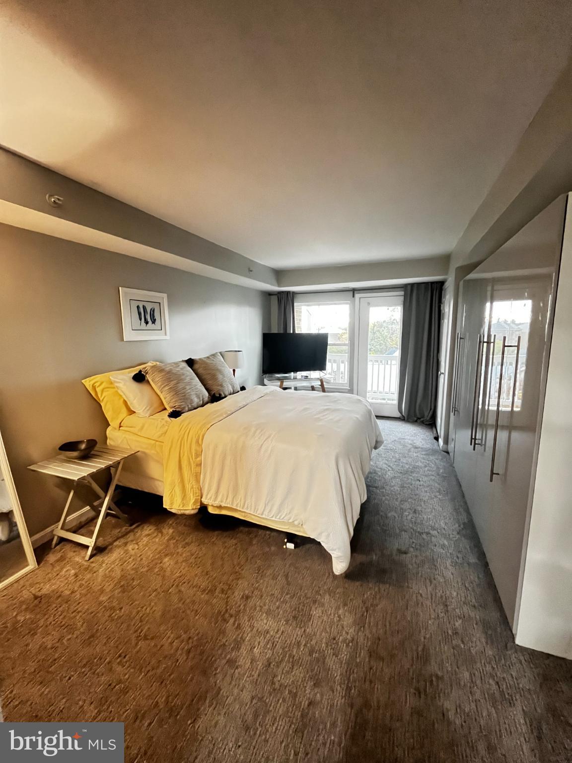 2609 Douglass Road Southeast, Unit 402 Washington, DC 20020 - Photo 27 of 35 a bedroom with a bed and wooden floor