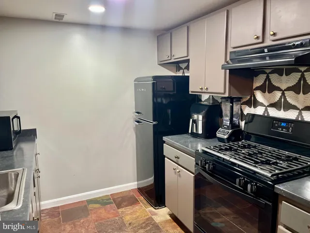 a kitchen with stainless steel appliances granite countertop a stove and a refrigerator