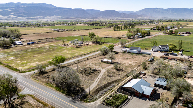 1211 West Midvalley Road Cedar City, UT 84721 - Photo 7 of 14 Expansive rural property featuring multiple structures, road frontage, and a mountainous backdrop