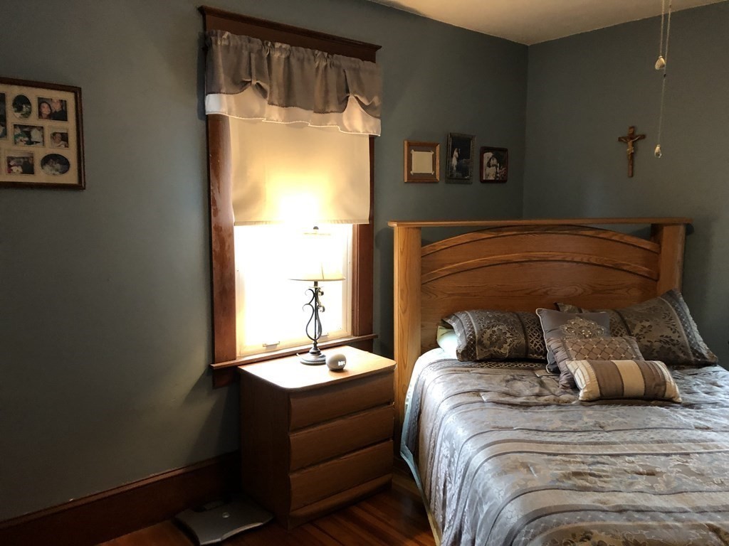 23 Acton Street Springfield, MA 01151 - Photo 19 of 33 a bed sitting in a bedroom next to a window