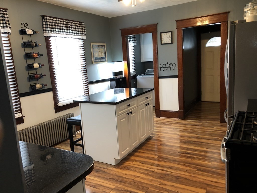 23 Acton Street Springfield, MA 01151 - Photo 5 of 33 a large kitchen with a sink and wooden floor