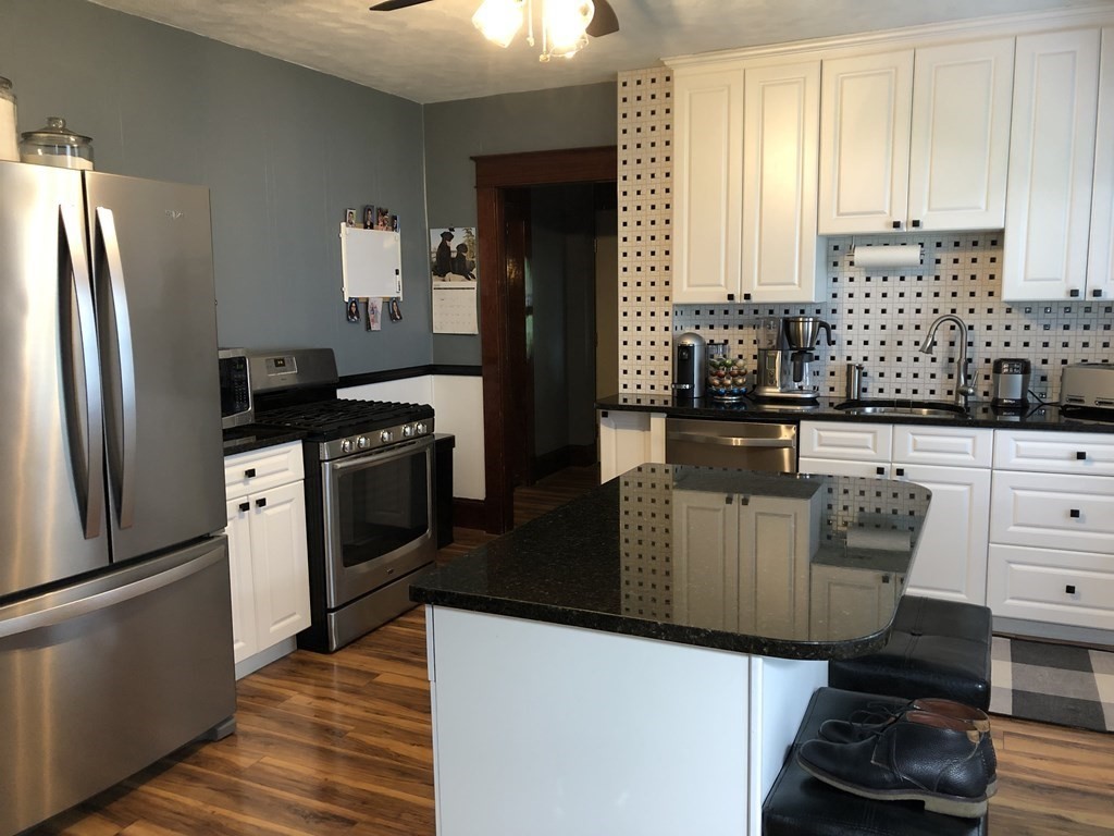 23 Acton Street Springfield, MA 01151 - Photo 6 of 33 a kitchen with stainless steel appliances kitchen island granite countertop a refrigerator a stove and a sink with cabinets