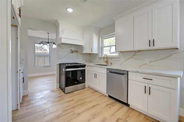 a view of an empty room with wooden floor and window