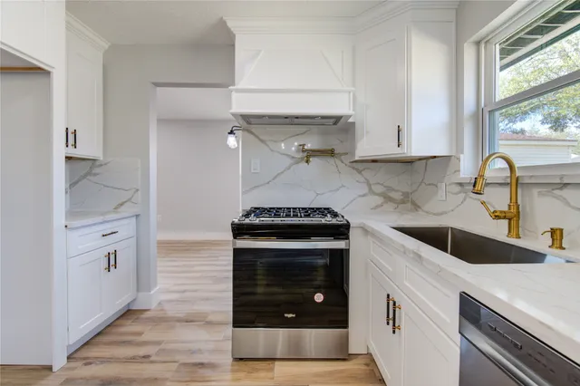 an empty room with wooden floor fireplace and window
