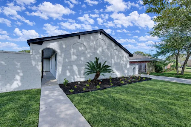 a view of an empty room with wooden floor and windows