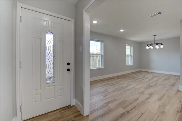 a kitchen with granite countertop white cabinets stainless steel appliances and wooden floor