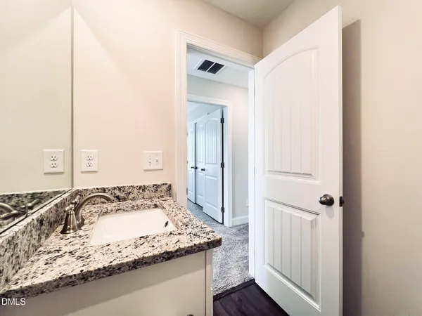 a bathroom with a granite countertop toilet sink and mirror