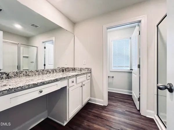 a bathroom with a glass shower door and a window