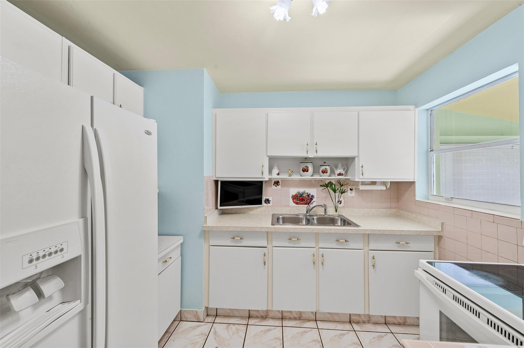946 Alamanda Road West Palm Beach, FL 33405 - Photo 37 of 56 a kitchen with white cabinets and white appliances